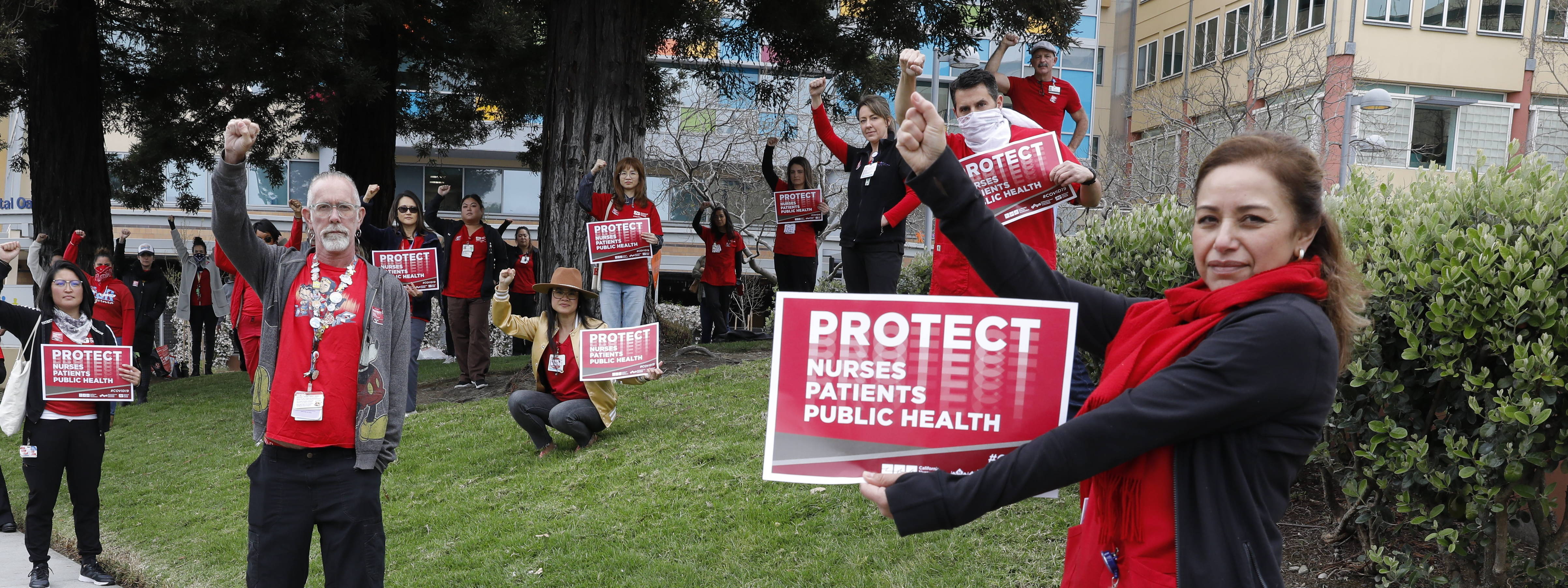 Nurses outside facility holding action