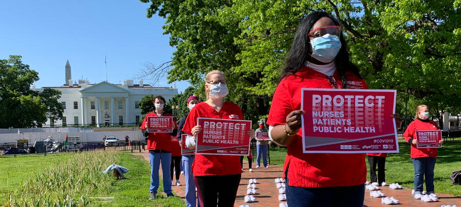 nurses holding signs outside White House