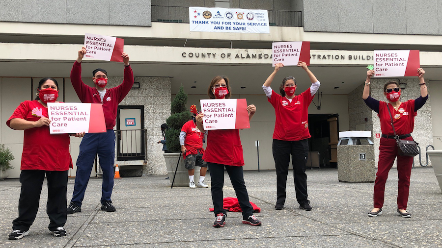 Nurses hold signs "Nurses Essential to Patient Care"