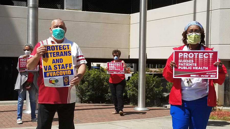 Nurses and hospital staff hold signs calling for prioritizing safety for staff anbd the public