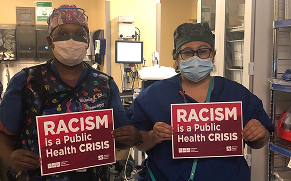 Nurses hold signs "Racism is a Public Health Crisis"