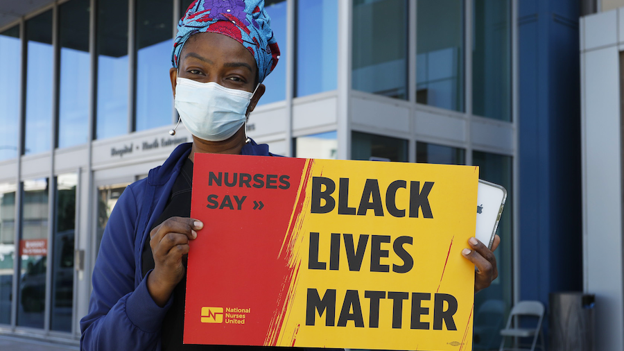 Nurse holds sign "Black Lives Matter"