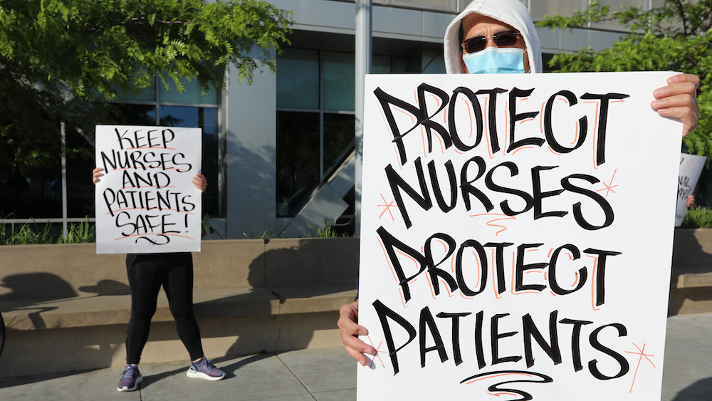 Nurse holds "Protect Nurses" signs