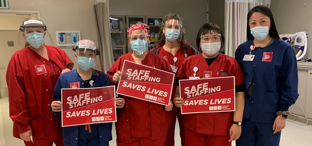 Nurses hold signs calling for safe staffing
