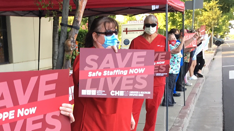 Nurses holds sign "Safe Staffing Now"