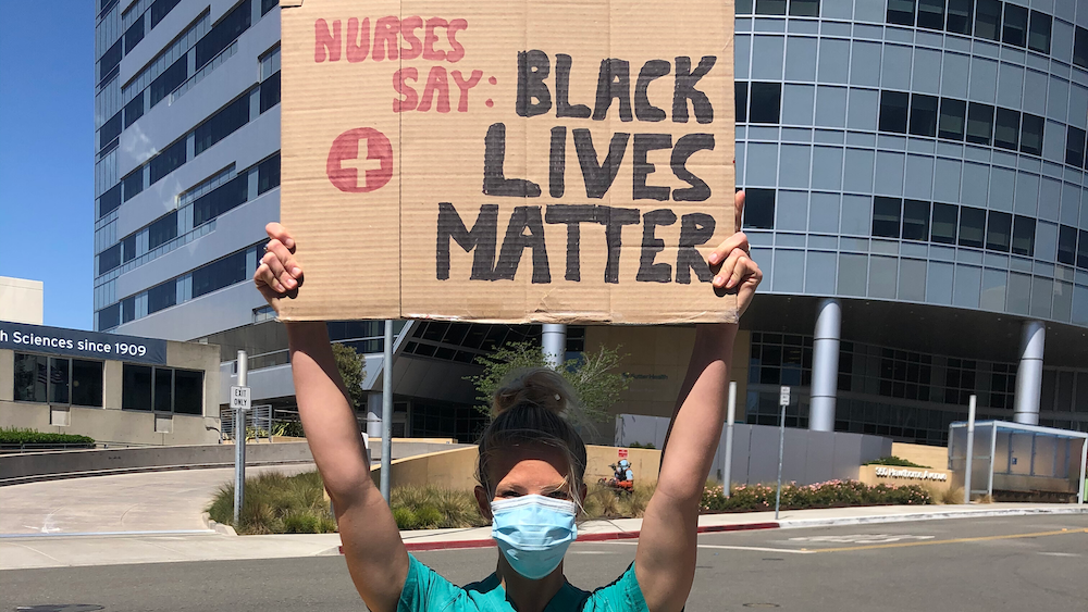 Nurse holds sign "Nurses say Black Lives Matter"