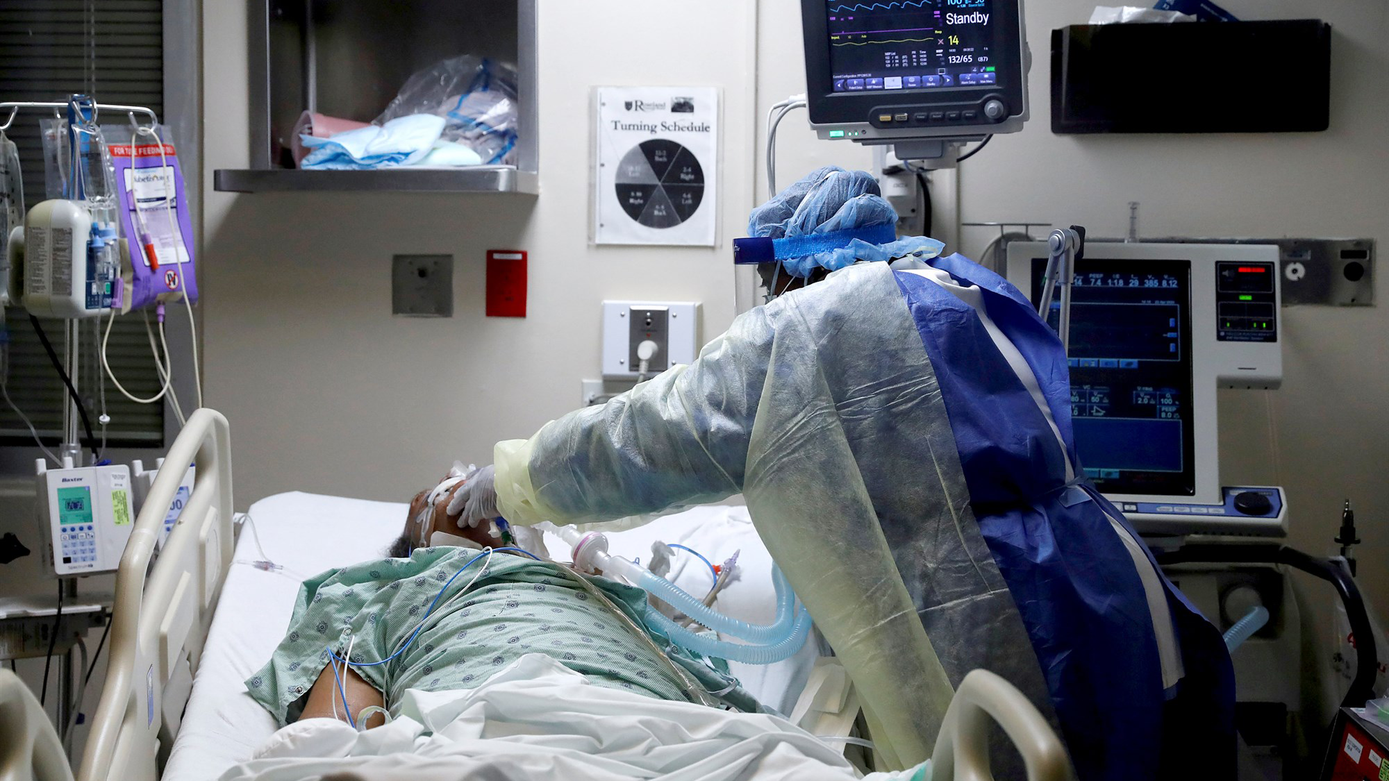 Nurse tends to patient in hospital bed