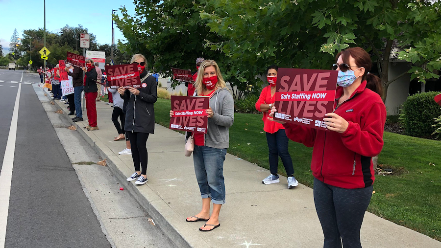 Nurses hold sign "Save Lives, Safe Staffing"