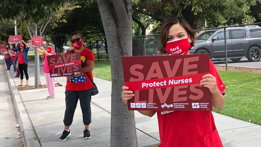 Nurse holds sing "Save Lives"