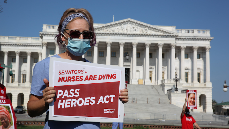 Nurse holds sign "Pass the HEROES Act" outside U.S. Senate