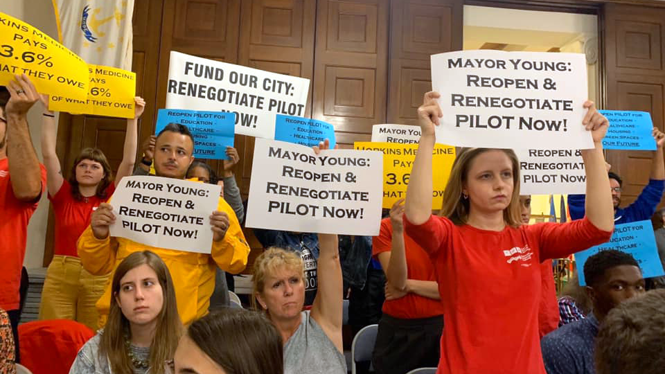People holding signs calling for pilot renogotiation