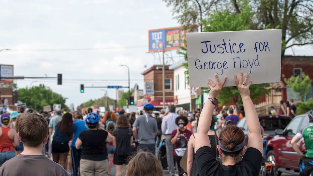 Crowd with person holding sign "Justice for George Floyd"