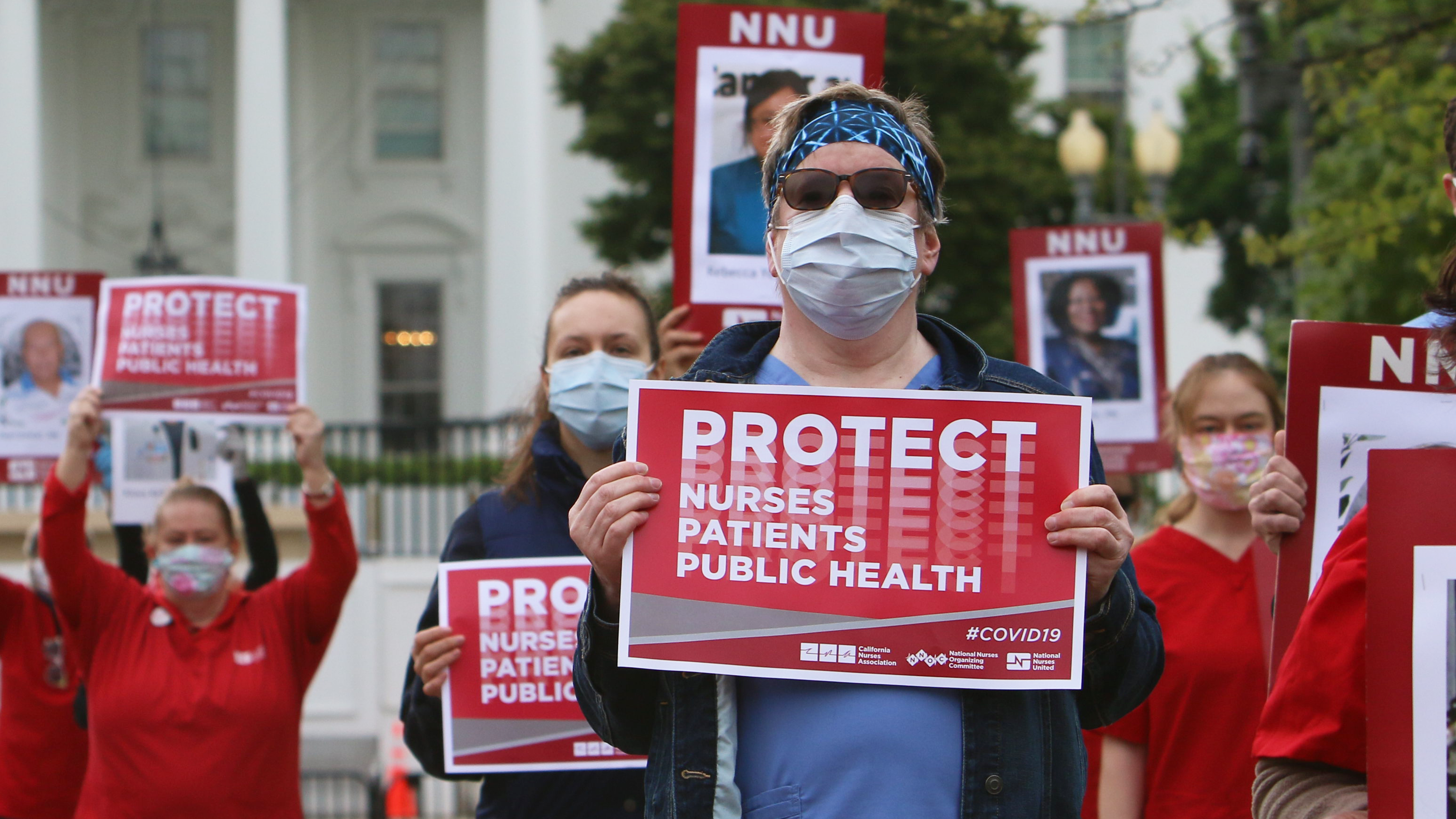 Nurses hold "Protect Nurses" signs outside the Whitehouse