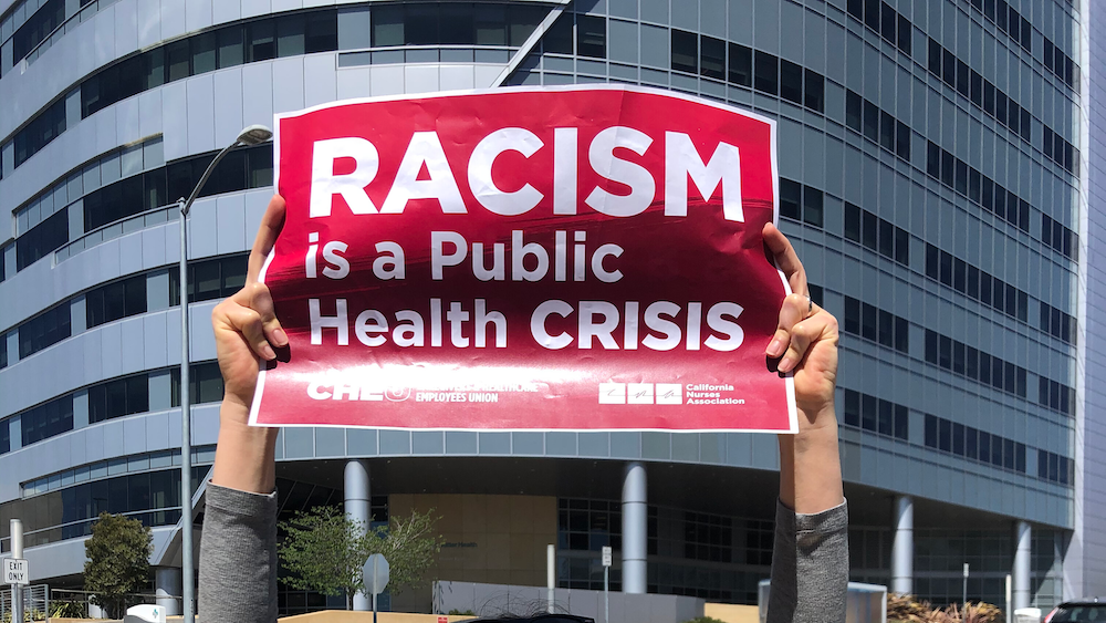 Nurses hold signs "Racism is a Public Health Crisis"