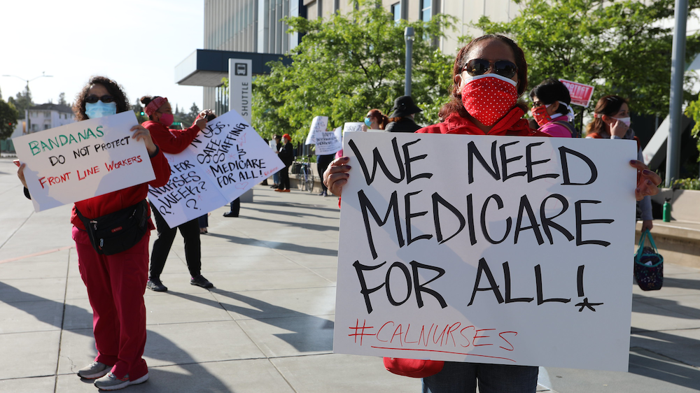 Nurse holding sign "We need Medicare for All"