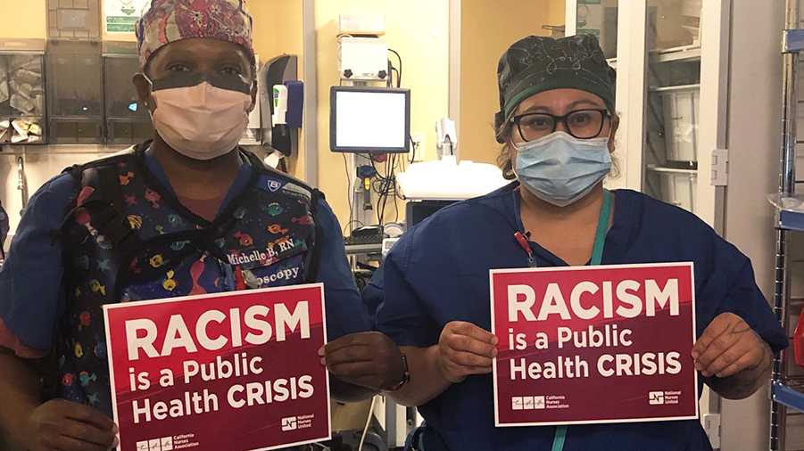 Nurses hold signs "Racism is a Public Health Crisis"