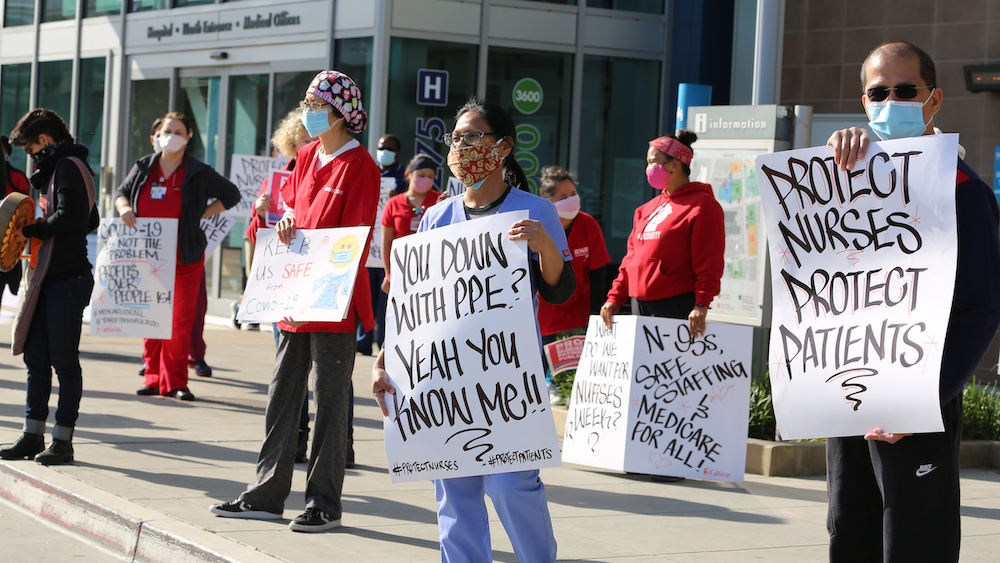 Nurses hold "Protect Nurses" signs