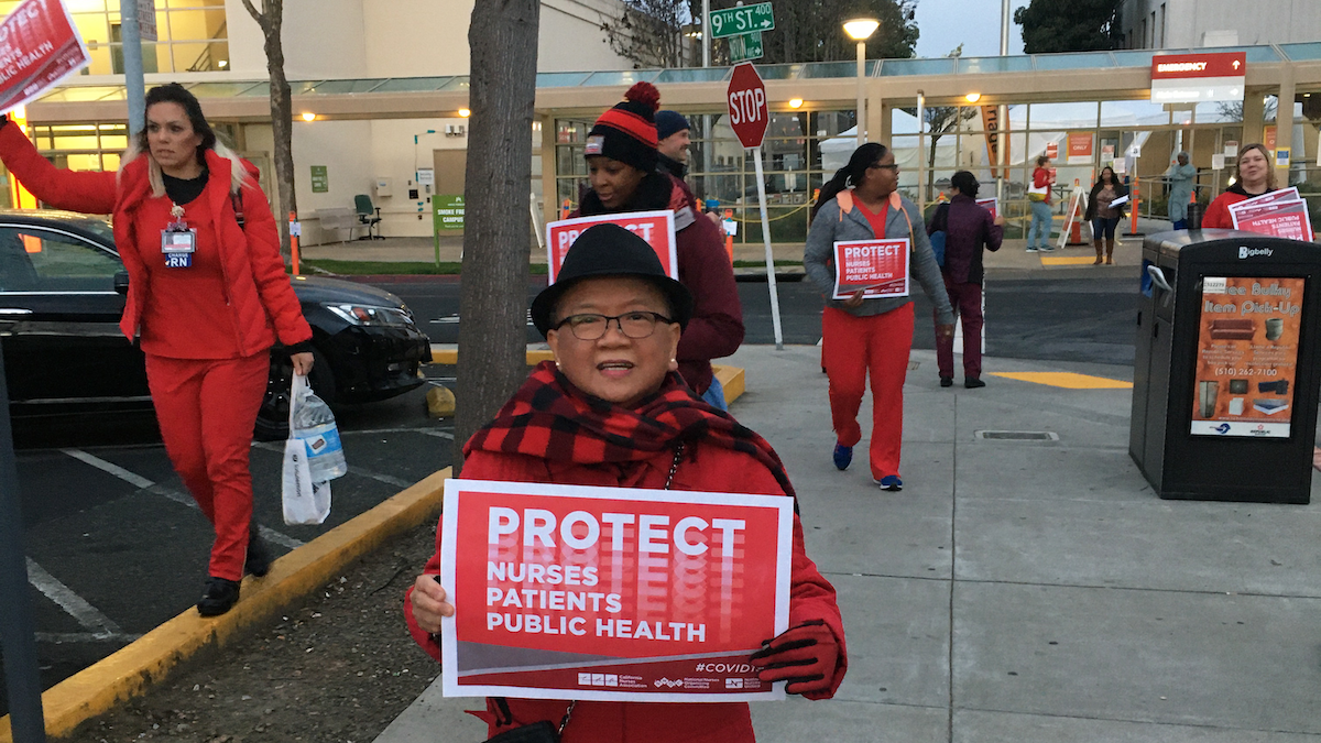 Nurse holds "Protect Nurses" signs