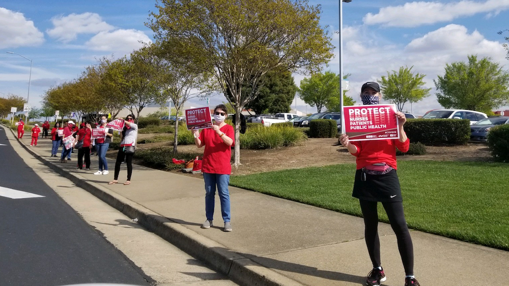 Nurses hold "Protect Nurses" signs 