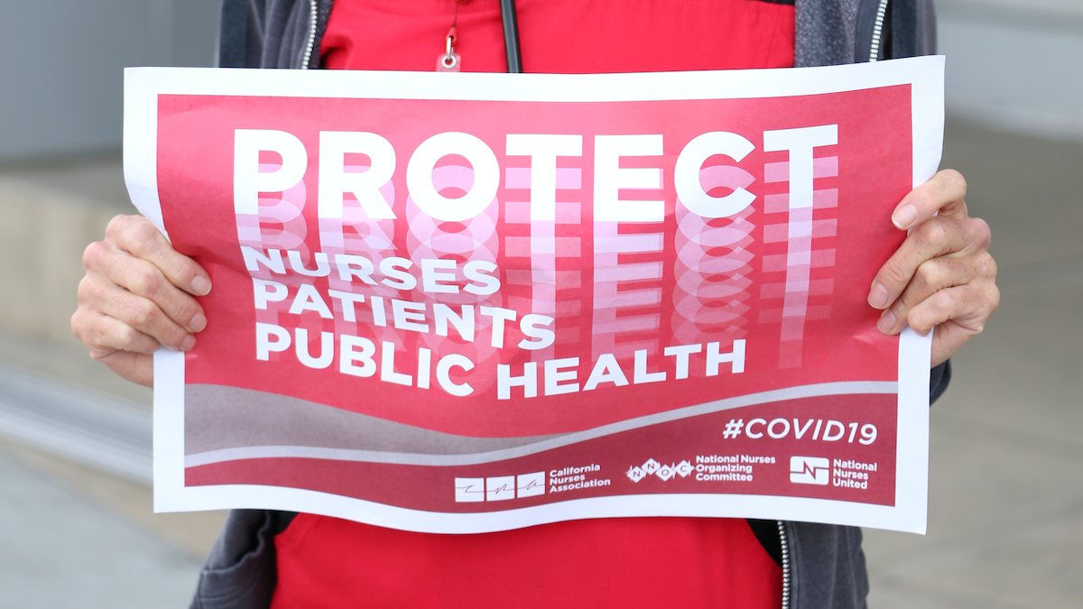 Nurse holds "Protect Nurses" sign