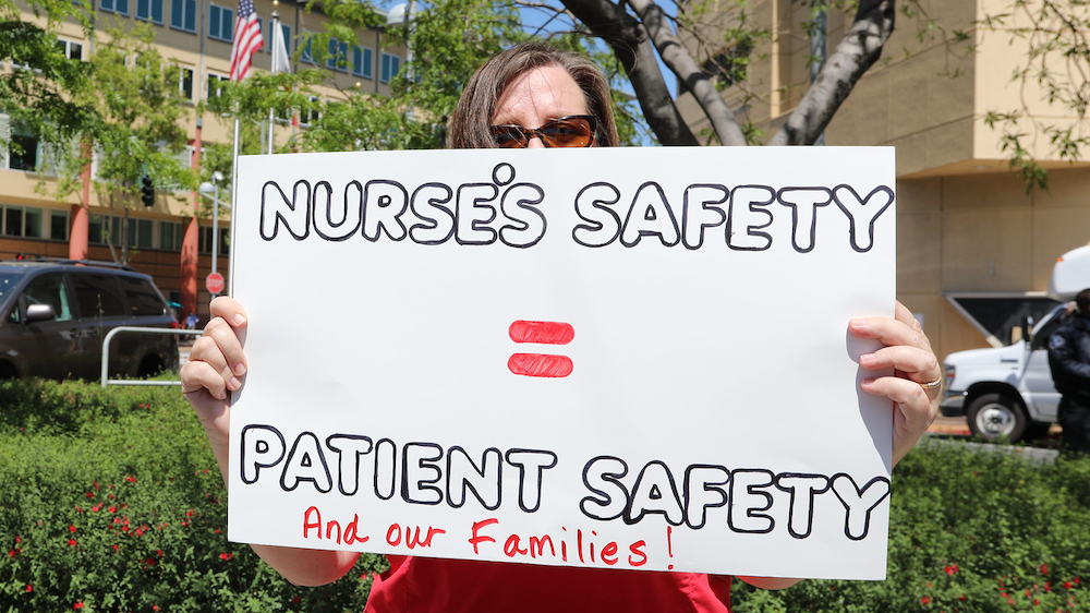 Nurses holds sign "Nurses safety = patient safety"