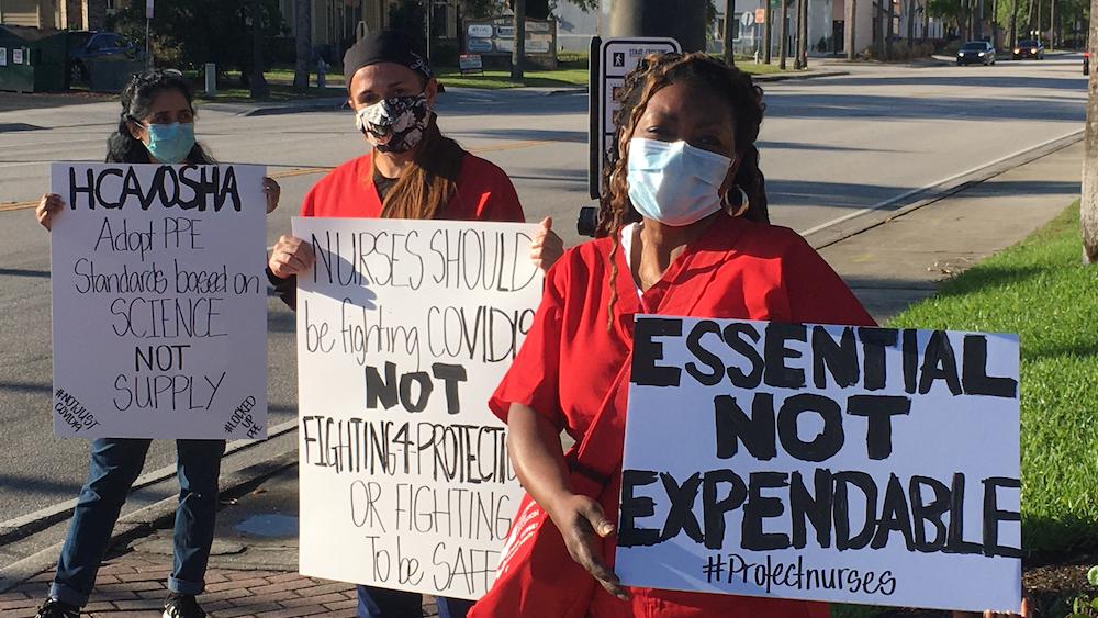 Nurses hold "Protect Nurses" signs