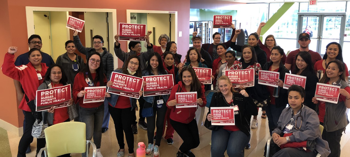 Nurses hold "Protect Nurses" signs