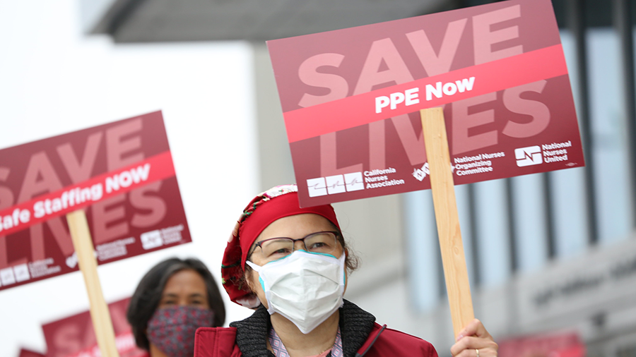 Nurses hold signs "Save Lives"