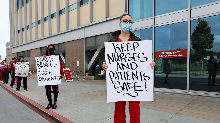 Nurses hold sign "Safe Nurses, Safe Patients"
