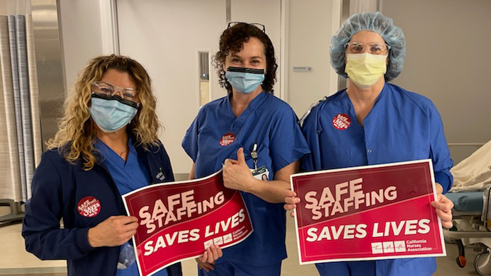 Nurses hold signs calling for safe staffing