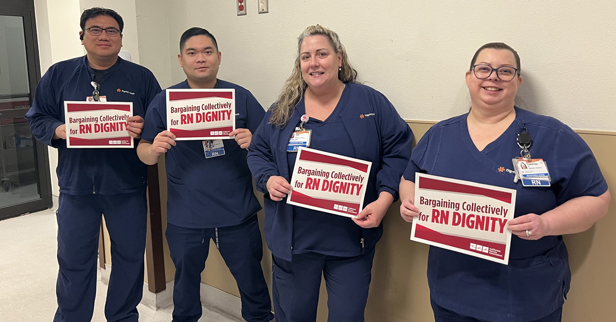 Dignity nurses holding signs that say "Nurses bargain for RN dignity."