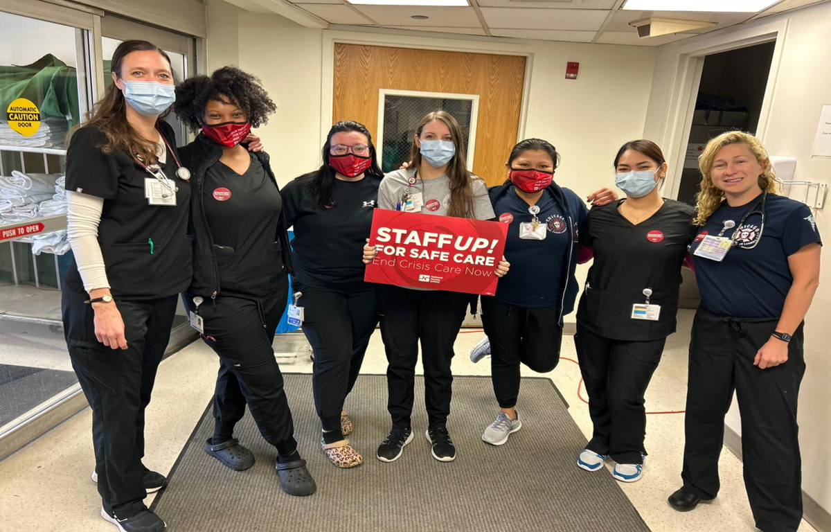 Nurses holding sign that reads "Staff up for safe care!"