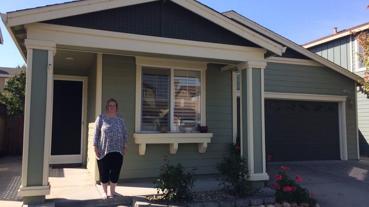 Cyndi Evans in front of her home