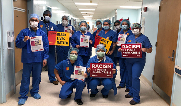 Nursews hold signs calling for racial justice