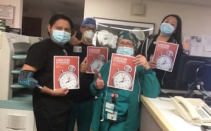 Four CHEU members inside the hospital hold signs "Union Strong"