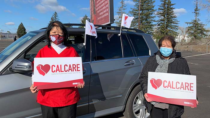 Nurses hold signs supporting CalCare