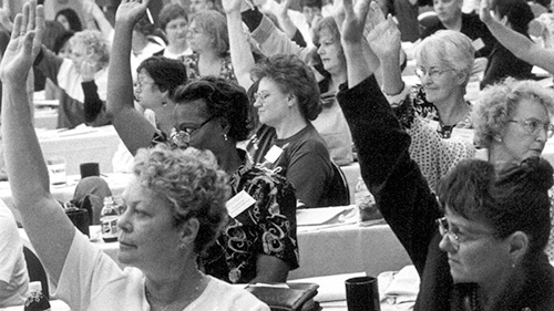 Nurses at convention with hands raised