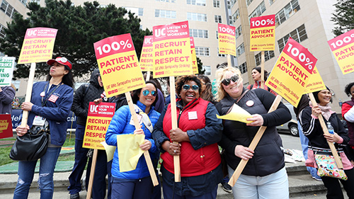 Nurses outside of UCSF hospital hold signs calling for nurse retention