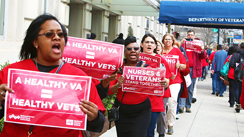 Nurses holding signs in support of care for veterans
