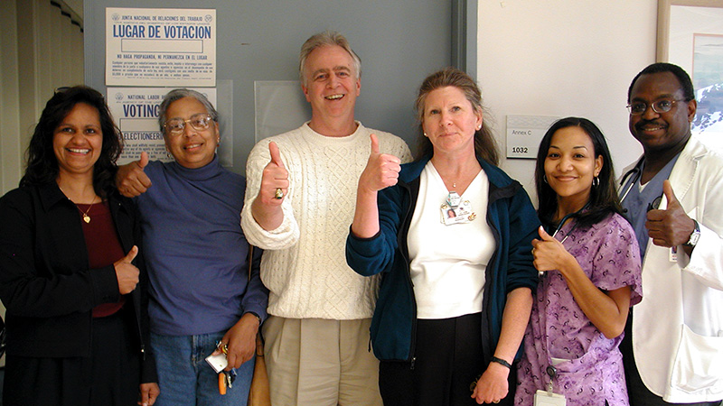 Group of health care workers inside hospital give thumbs up