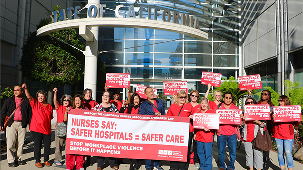 Nurses hold signs calling for workplace violcence prevention