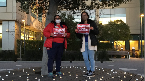 Nurses hold signs "Racism is a public health crisis