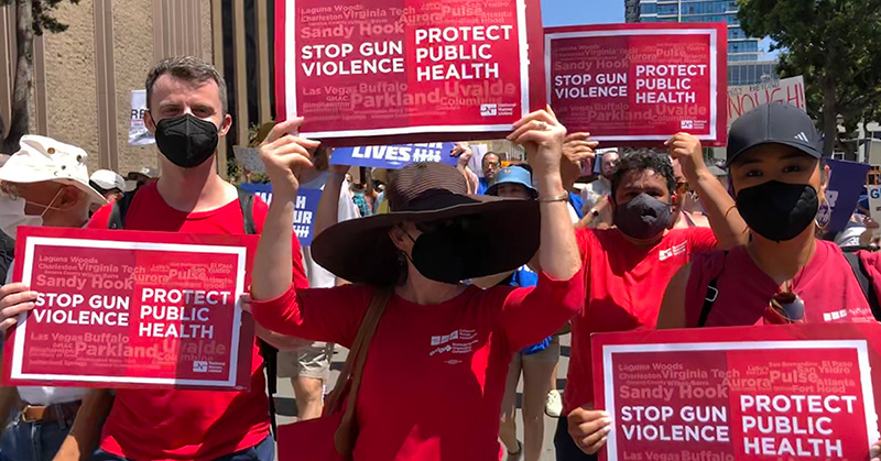 Nurses outside hold signs "Stop Gun Violence: Protect Public Health"