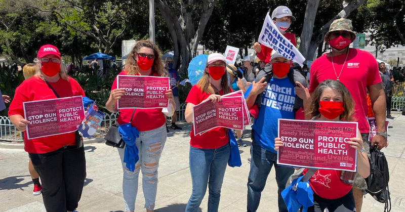 Nurses and families hold signs "Stop Gun Violence: Protect Public Health"