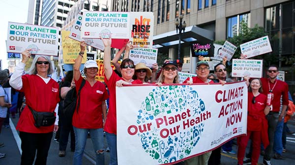 Nurses hold banner calling for climate justice