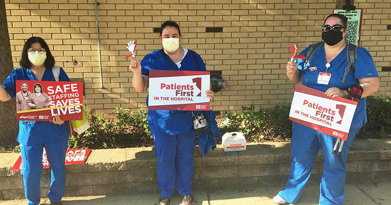 3 nurses outside hold signs "Patients First in the Hospital"