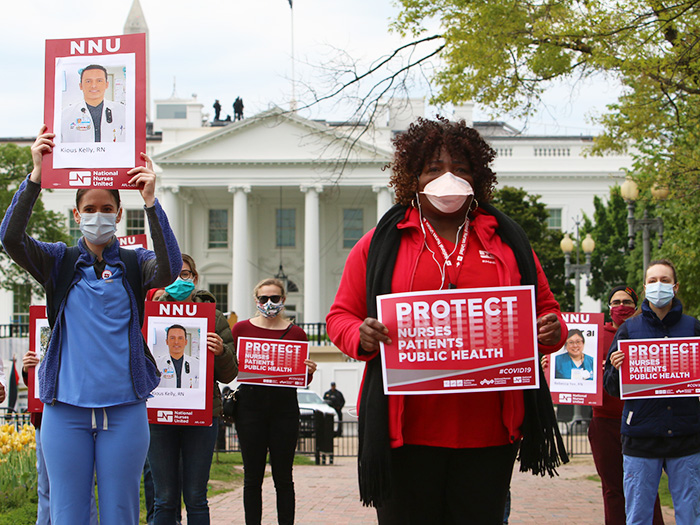 Nurses outside The White House holds sign "Protect Nurses, Patients, Public Health"