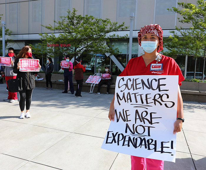 Nurse holds sign "Science matters. We are not expendable."