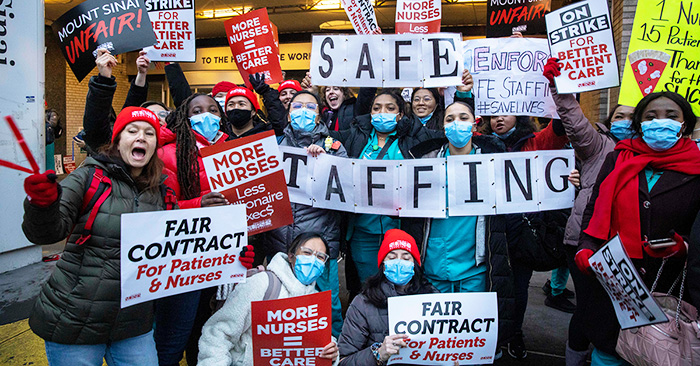 Large group of nurses holding signs calling for Safe Staffing