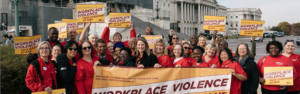 Nurses hold signs calling for workplace violence prevention